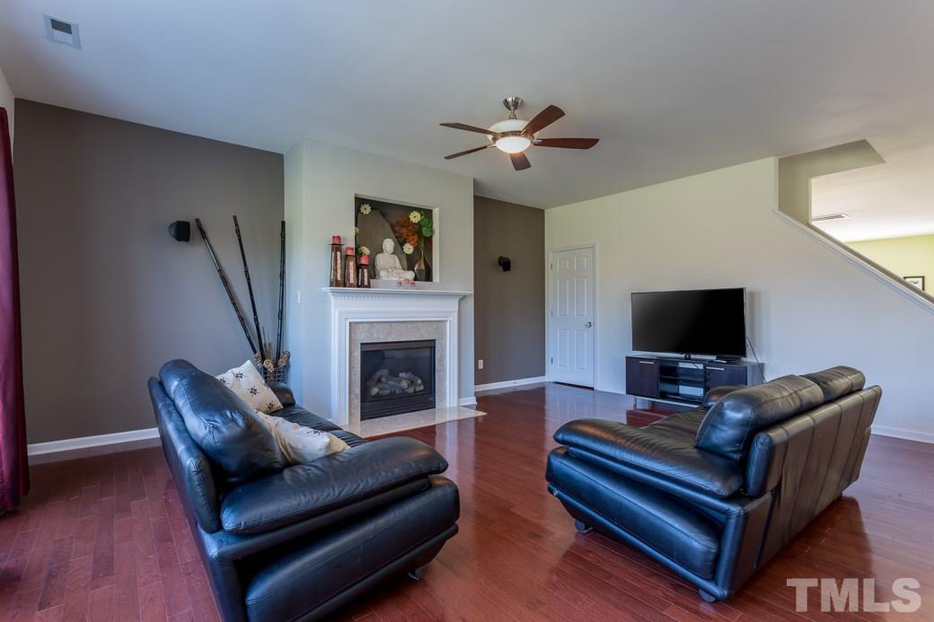 4357 Karlbrook Lane Raleigh, NC 27616 - Photo 7 of 25 a living room with furniture a flat screen tv and a fireplace