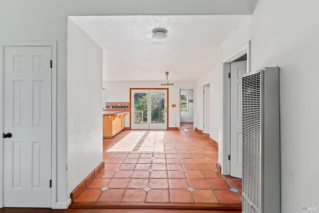 a view of a hallway with wooden floor and glass door