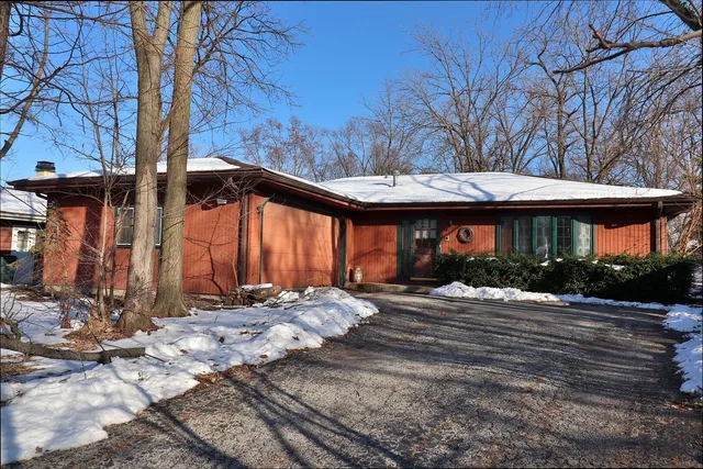a front view of house with yard and trees around