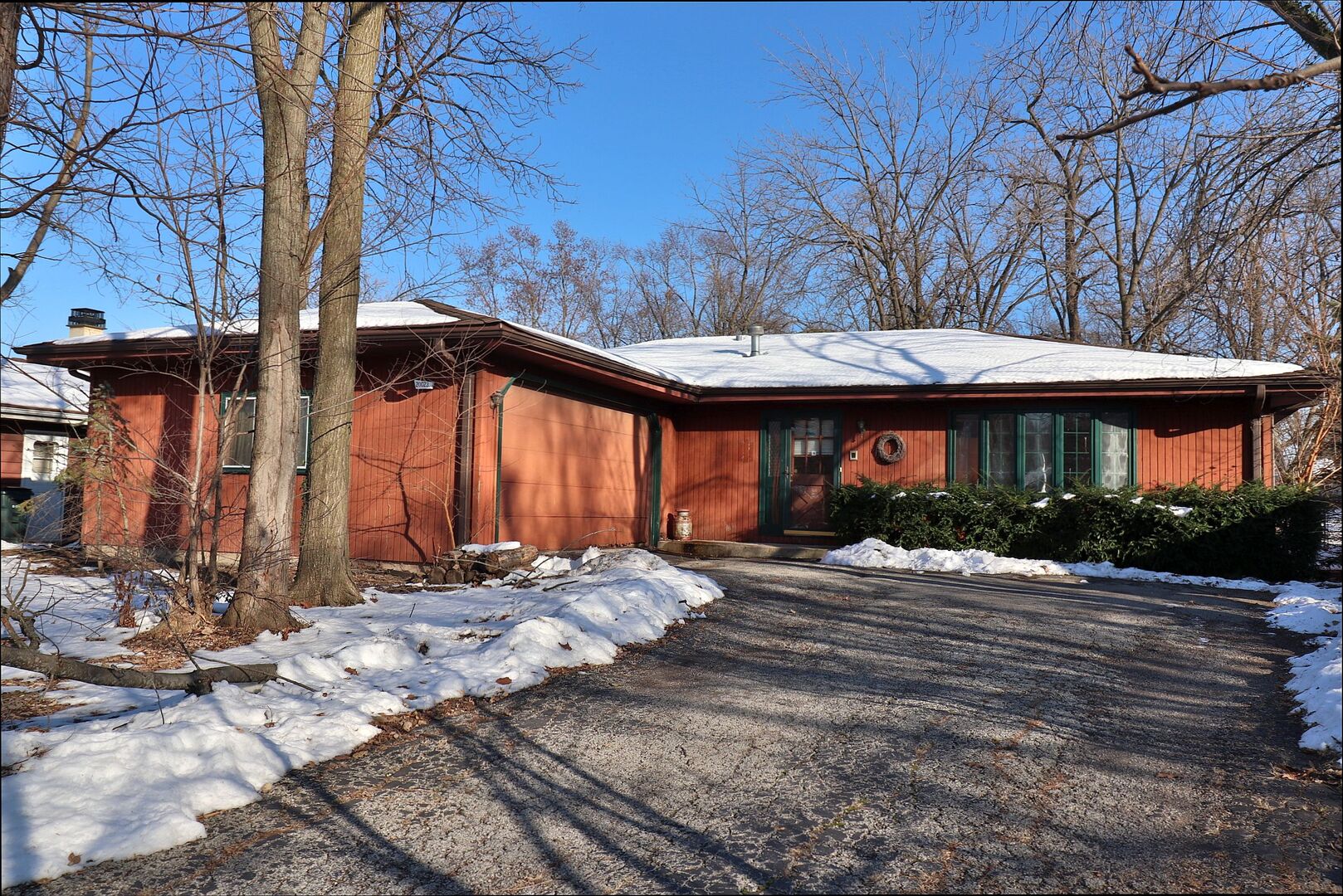 a front view of house with yard and trees around