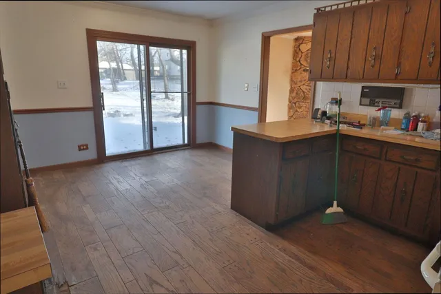 a kitchen with a sink a stove cabinets and wooden floor