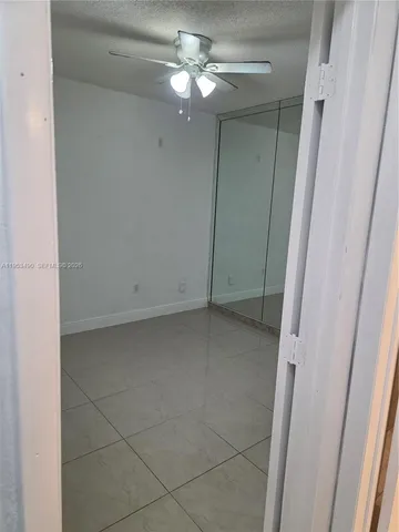 an empty room with chandelier fan