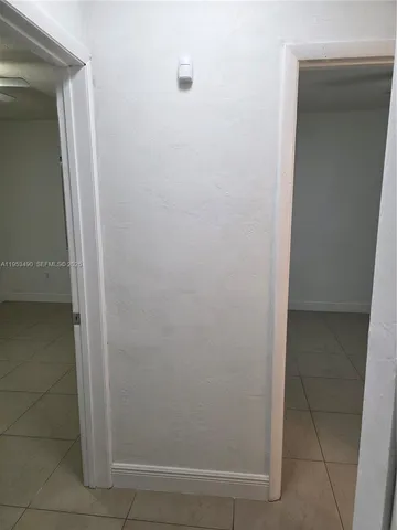 an empty room with a chandelier fan