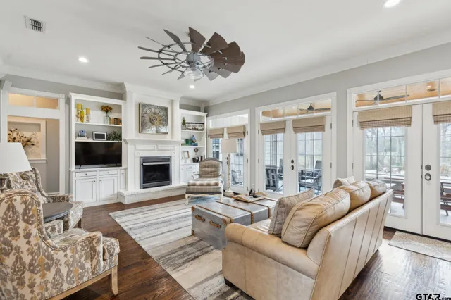 a living room with furniture a fireplace and a chandelier