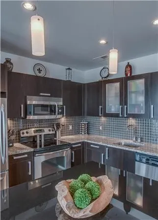 a kitchen with kitchen island stainless steel appliances a sink and a stove