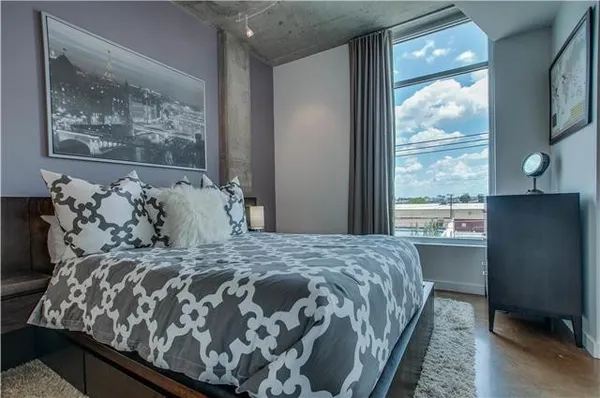 a large bed sitting in a bedroom next to a window