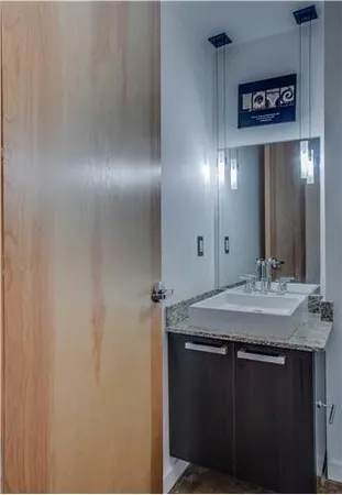 a bathroom with a granite countertop sink and a mirror