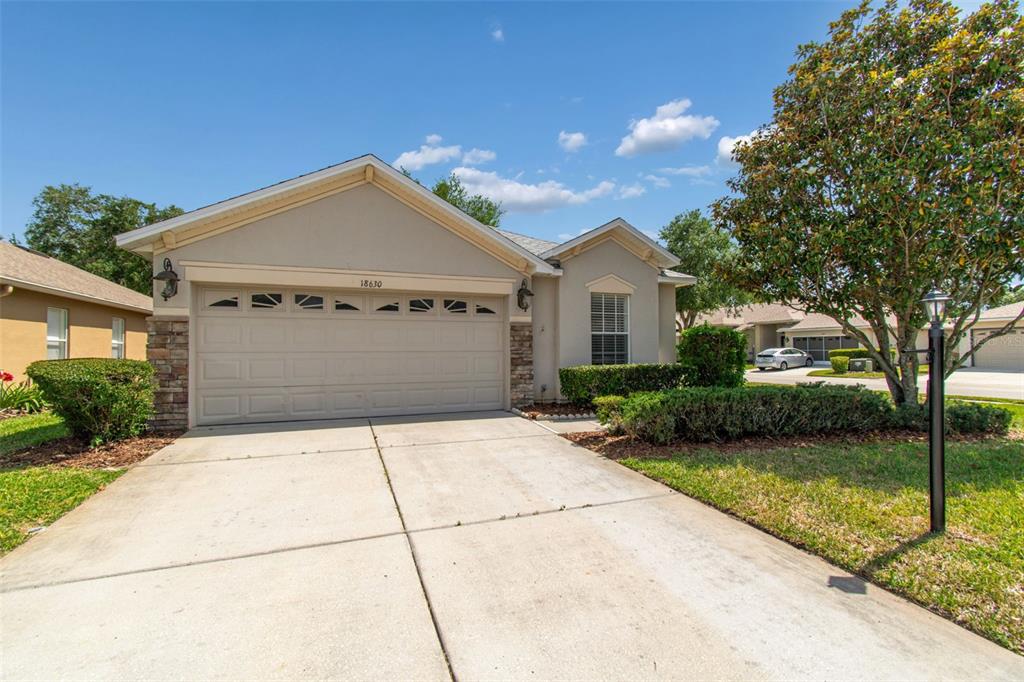 18630 Rolling Hills Loop Hudson, FL 34667 - Photo 2 of 64 a front view of a house with a yard and garage