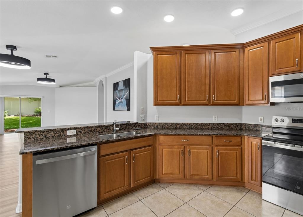 18630 Rolling Hills Loop Hudson, FL 34667 - Photo 22 of 64 a kitchen with granite countertop a sink and white cabinets