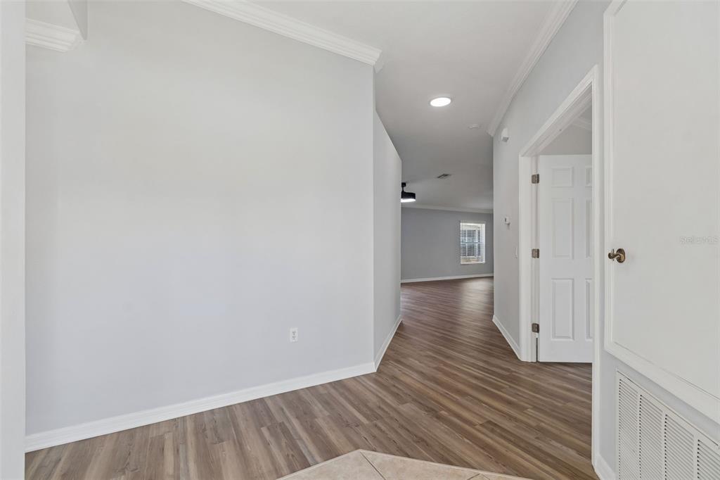 18630 Rolling Hills Loop Hudson, FL 34667 - Photo 7 of 64 a view of an empty room with wooden floor and a bathroom