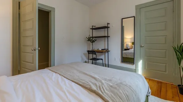 a bedroom with a bed and a painting on the wall