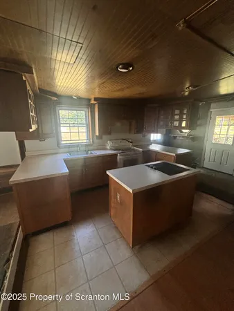 a large kitchen with stainless steel appliances a counter space and a window