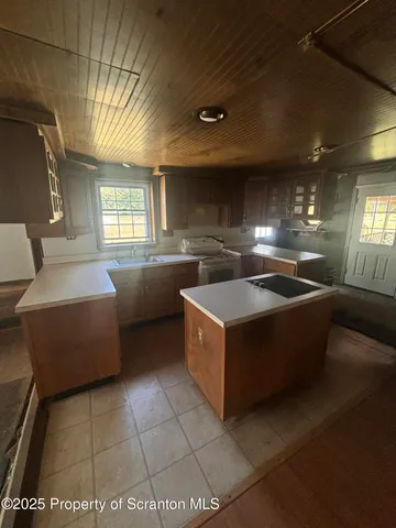 a large kitchen with stainless steel appliances a counter space and a window