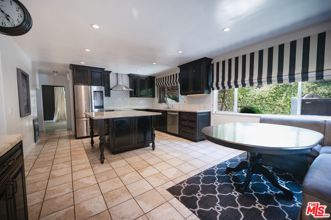 503 North Greencraig Road Los Angeles, CA 90049 - Photo 14 of 59 a kitchen with stainless steel appliances a dining table chair and a refrigerator