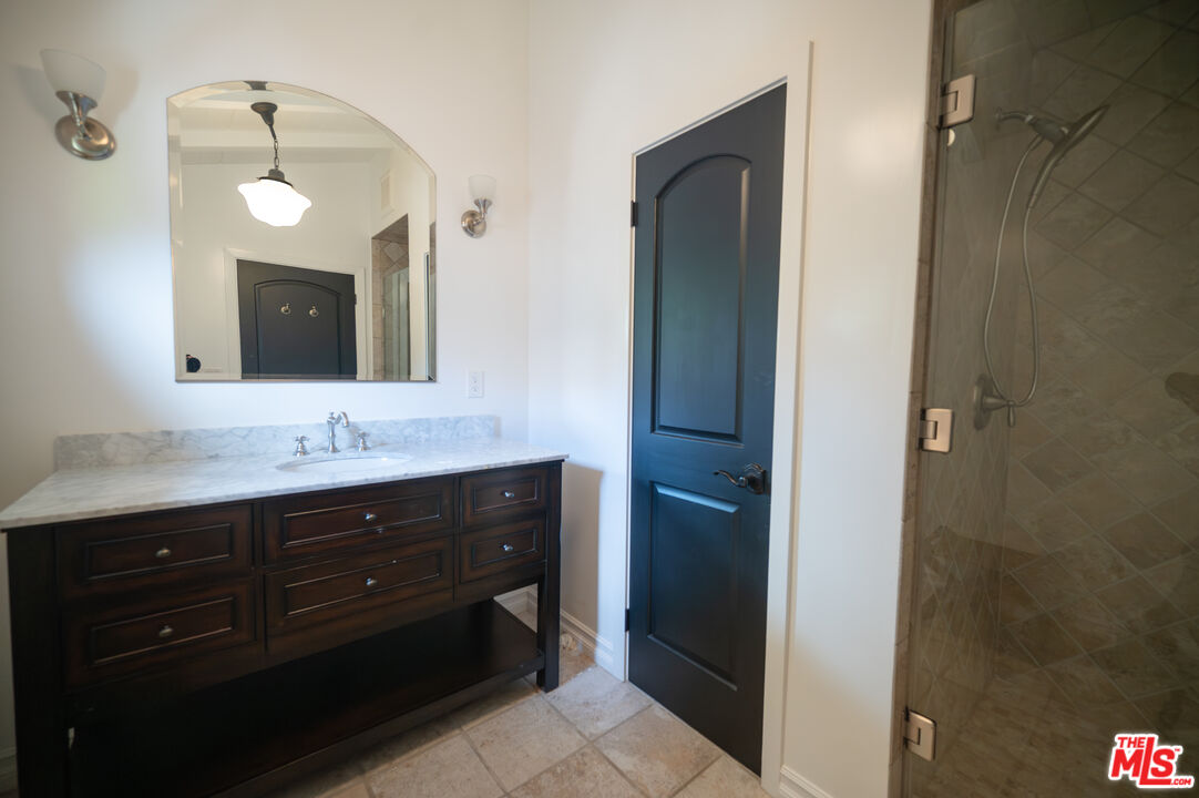 503 North Greencraig Road Los Angeles, CA 90049 - Photo 25 of 59 a bathroom with a double vanity sink and a mirror