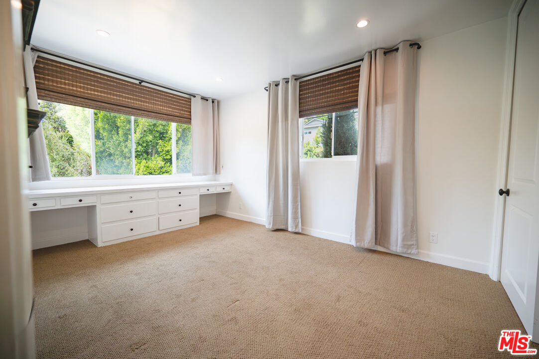 503 North Greencraig Road Los Angeles, CA 90049 - Photo 31 of 59 a view of an empty room with window a ceiling fan and wooden floor