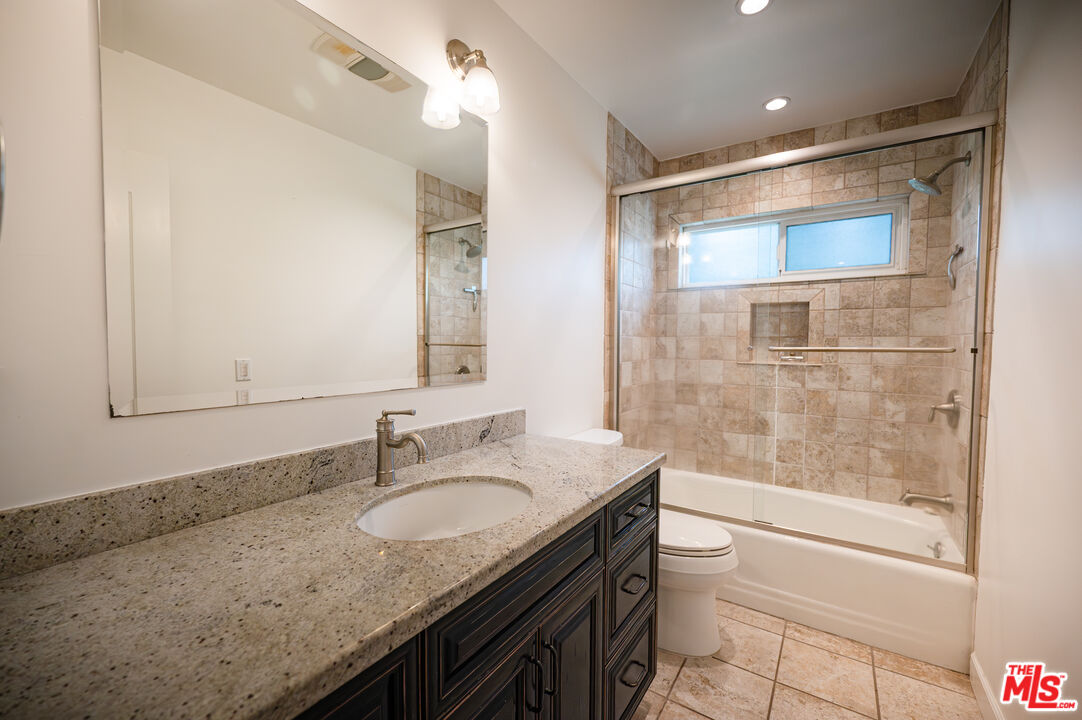503 North Greencraig Road Los Angeles, CA 90049 - Photo 32 of 59 a bathroom with a granite countertop sink a toilet and shower