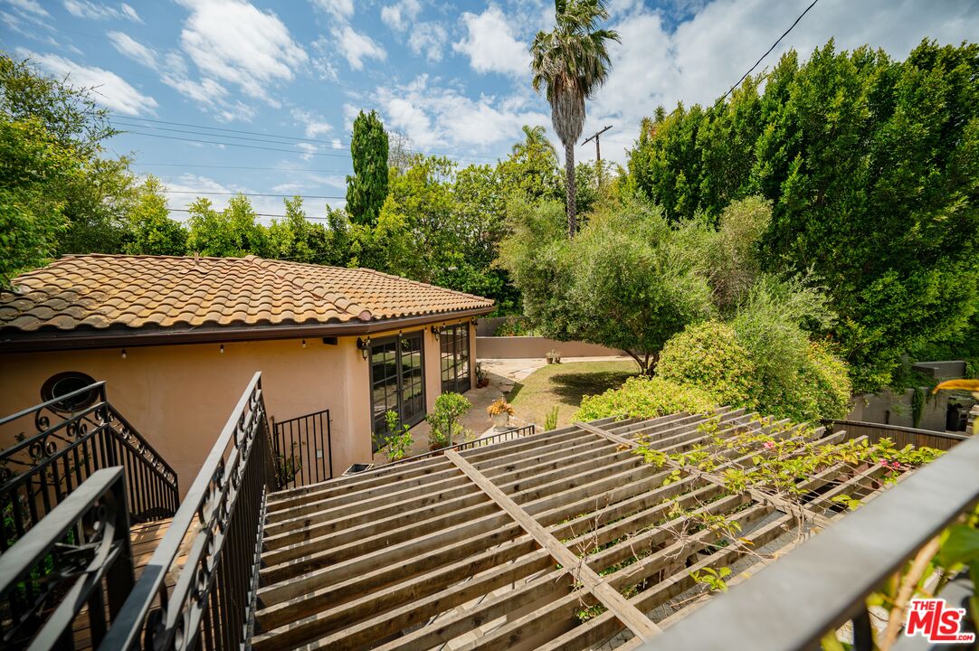 503 North Greencraig Road Los Angeles, CA 90049 - Photo 55 of 59 a view of a patio with table and chairs with wooden floor and fence