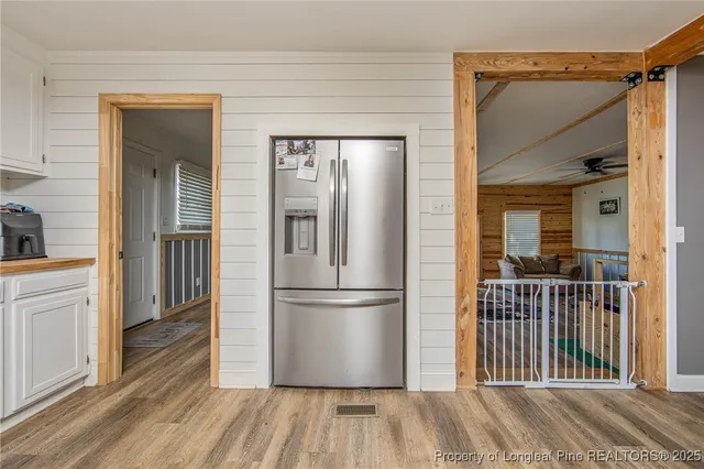 a view of a dining room and livingroom with furniture wooden floor a chandelier