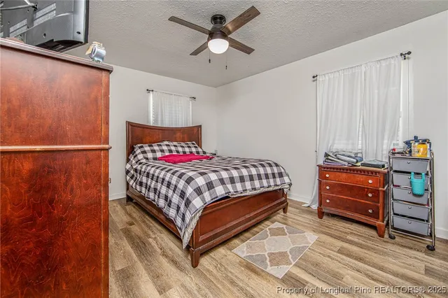 a bedroom with a bed and wooden floor