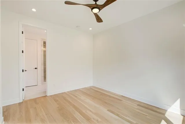 a view of a room with a ceiling fan and wooden floor