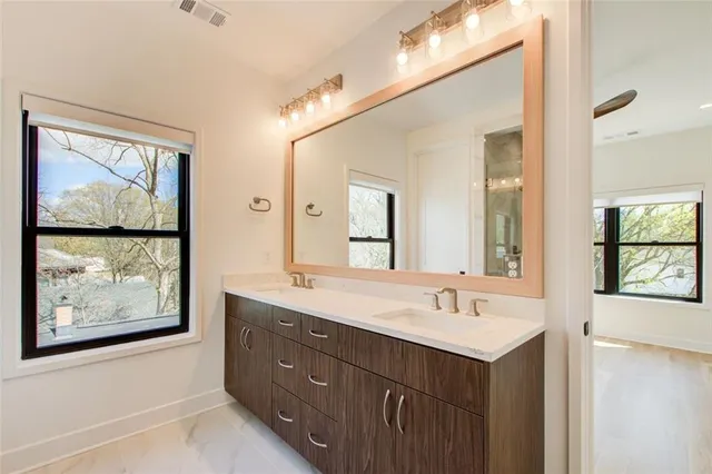 a bathroom with a double vanity sink and a large mirror