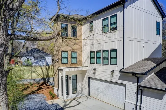 a view of a house with a balcony and next to a yard