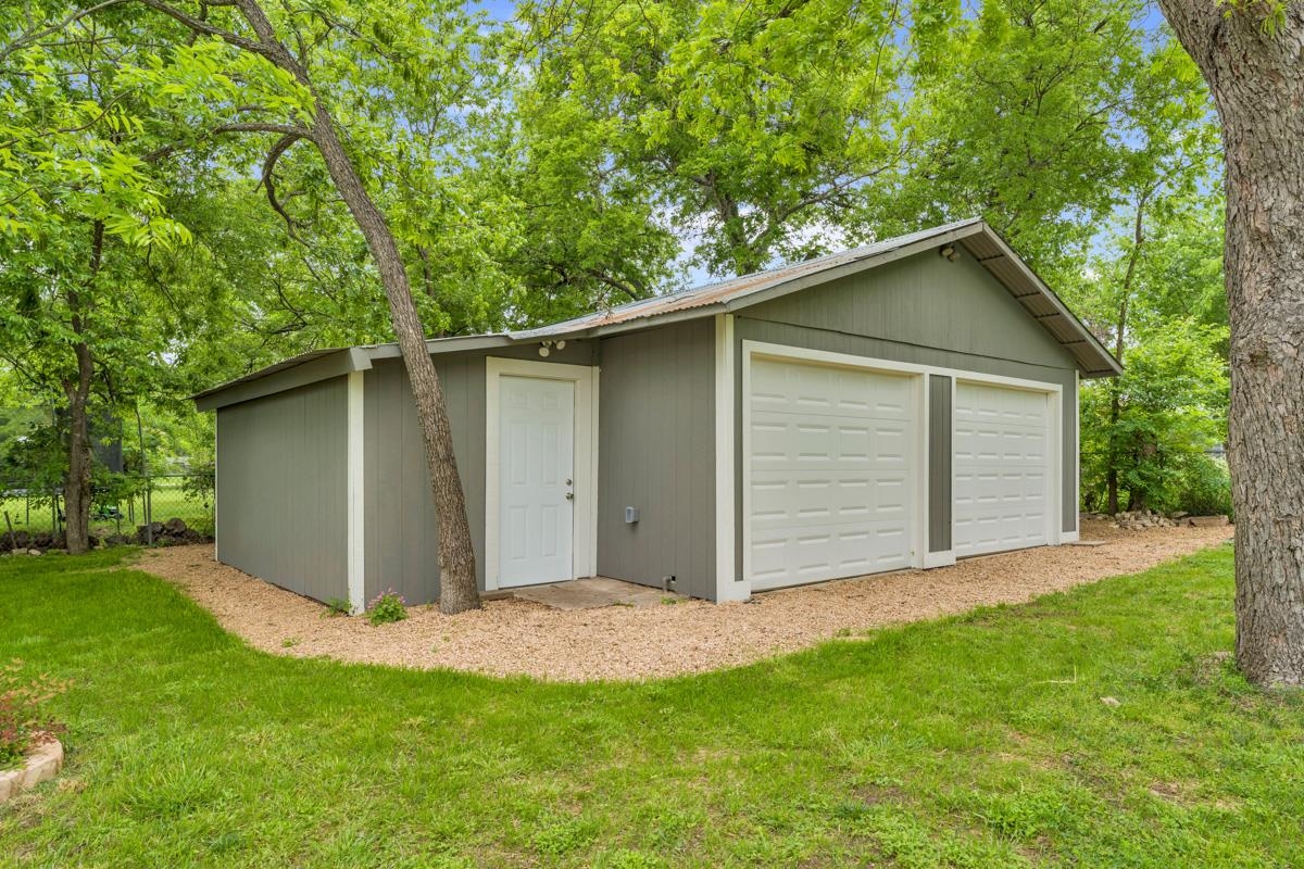 407 East Kerr Street Burnet, TX 78611 - Photo 20 of 21 a backyard of a house with plants and large tree
