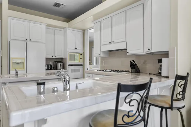 a living room with furniture a flat screen tv and a potted plant