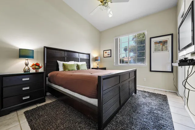 a bedroom with a bed and a lamp on a dresser