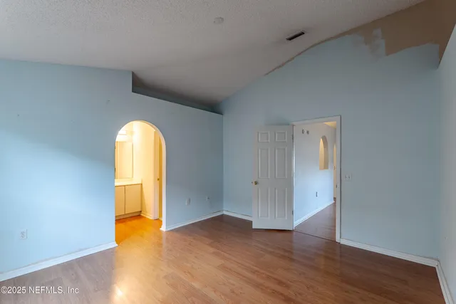 a view of empty room with wooden floor