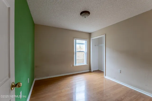 a view of an empty room with window and closet area