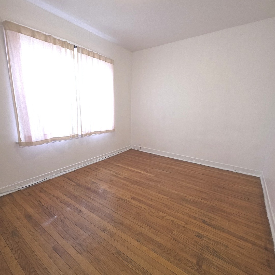 1248 North Spaulding Avenue, Unit 2 Chicago, IL 60651 - Photo 11 of 12 an empty room with wooden floor and windows