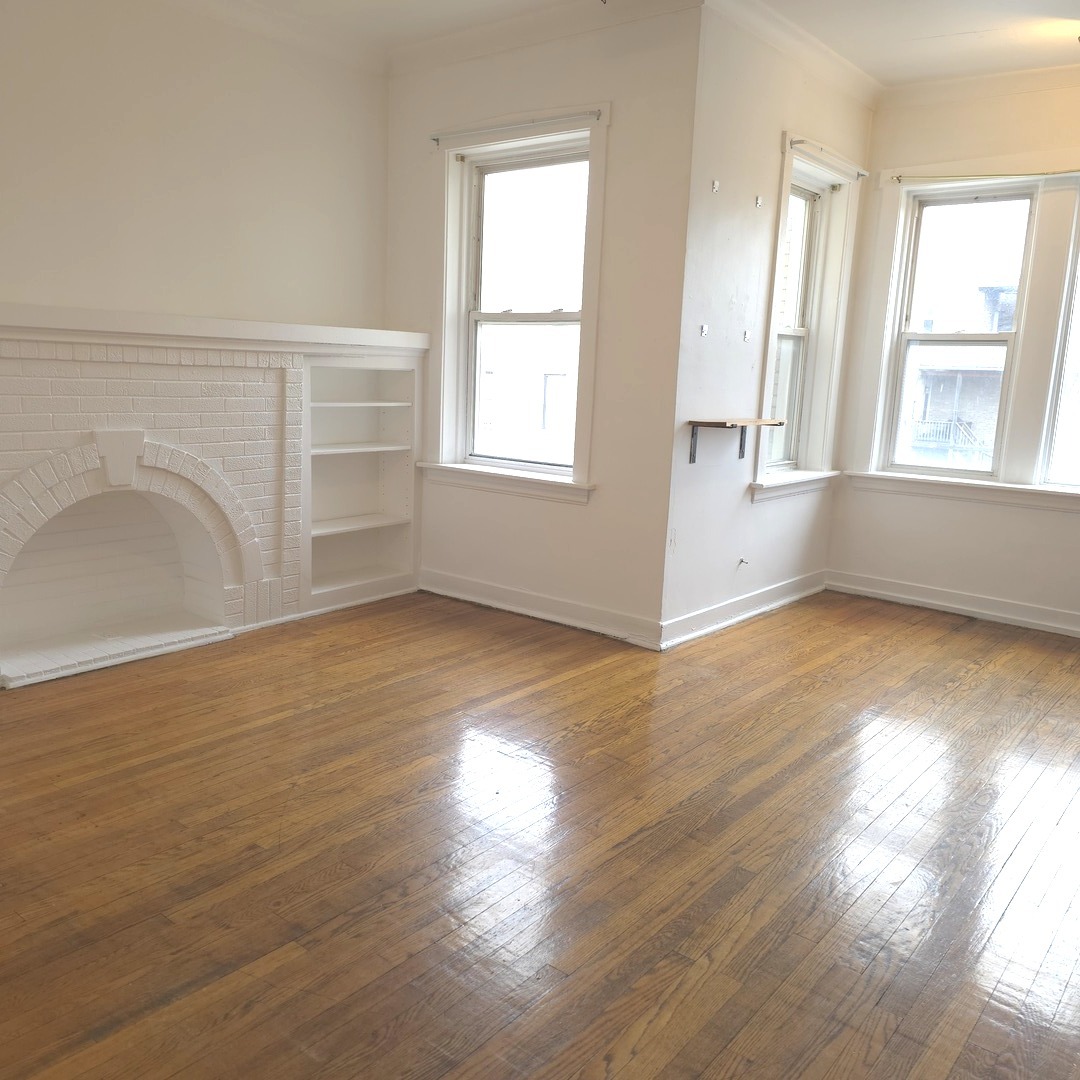 1248 North Spaulding Avenue, Unit 2 Chicago, IL 60651 - Photo 3 of 12 a view of an empty room with wooden floor and a window