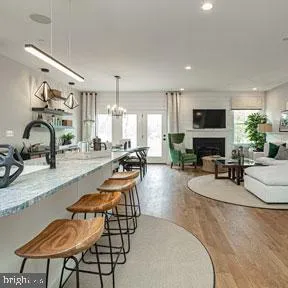 a room with furniture a fireplace and a view of kitchen