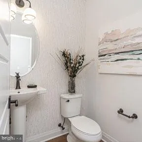 a bathroom with a toilet a sink and mirror
