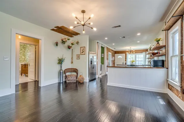 a view of a livingroom with furniture wooden floor a ceiling fan and windows