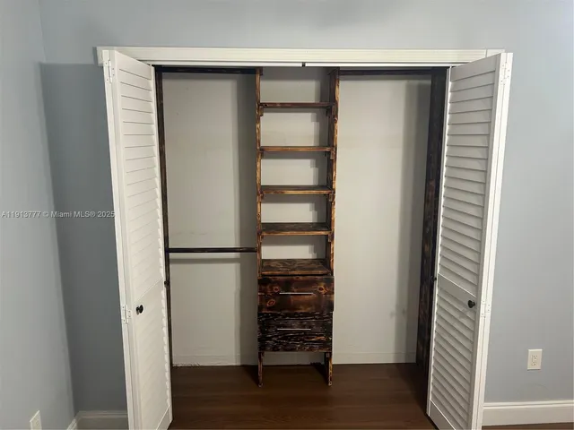a view of walk in closet with empty racks