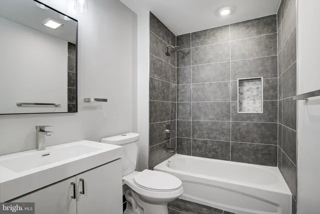 a bathroom with a bathtub shower sink vanity and toilet