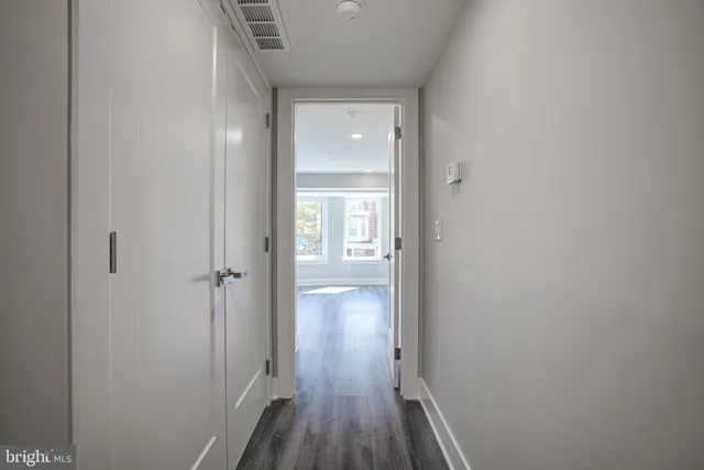 a view of a hallway with wooden floor
