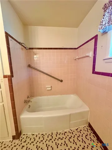 a bathroom with a bathtub and a shower