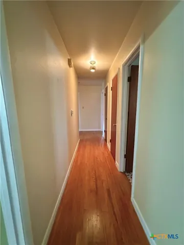 a view of a hallway with wooden floor