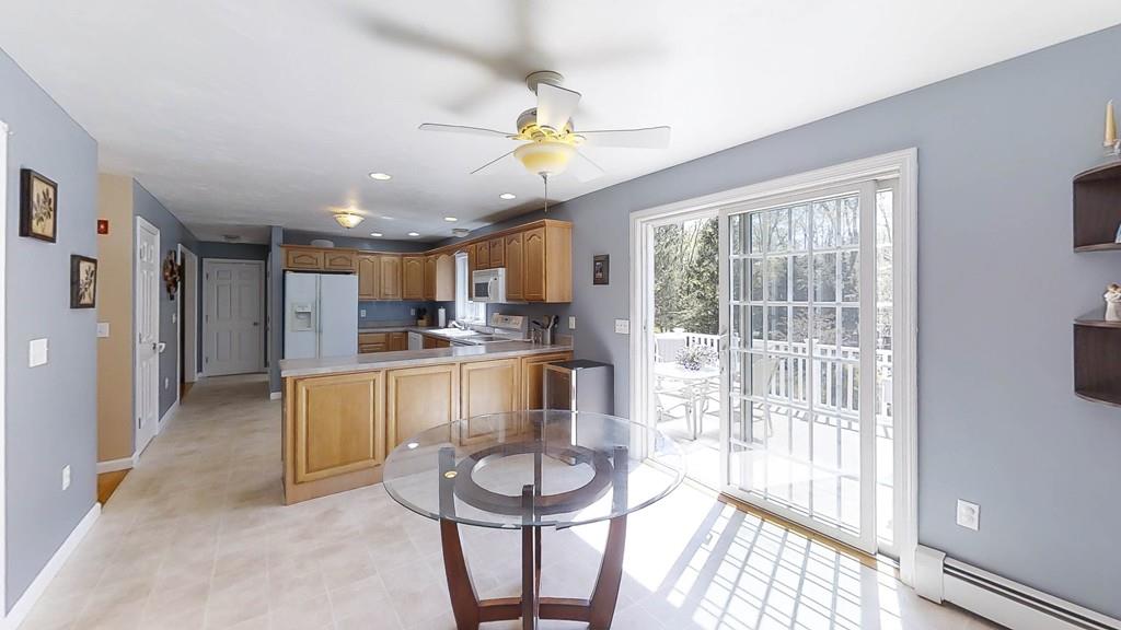 1079 North Brookfield Road Oakham, MA 01068 - Photo 19 of 40 a kitchen with a refrigerator a sink dishwasher a dining table and chairs with wooden floor