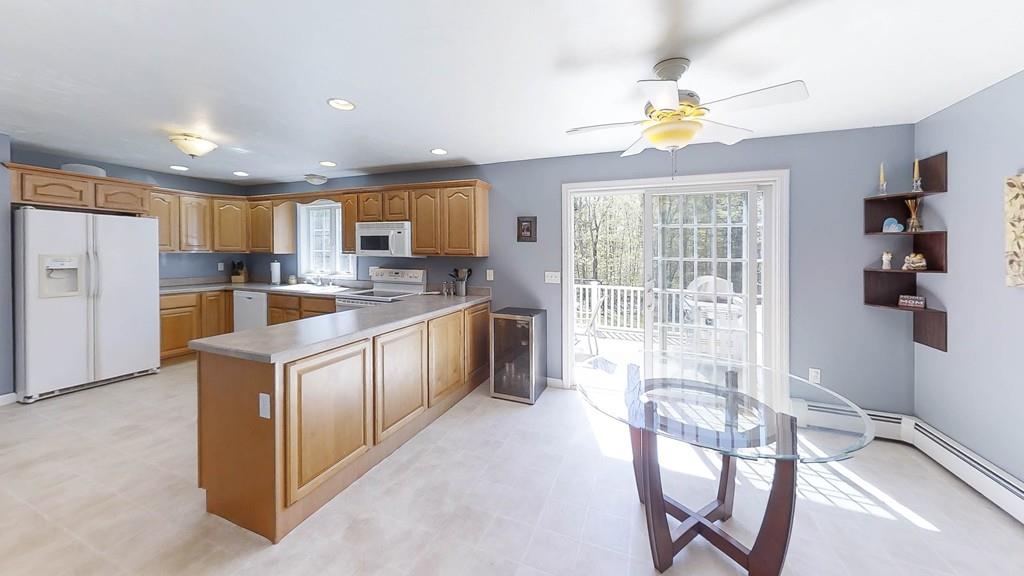 1079 North Brookfield Road Oakham, MA 01068 - Photo 8 of 40 a kitchen with stainless steel appliances granite countertop a stove top oven a sink dishwasher a dining table and chairs with wooden floor
