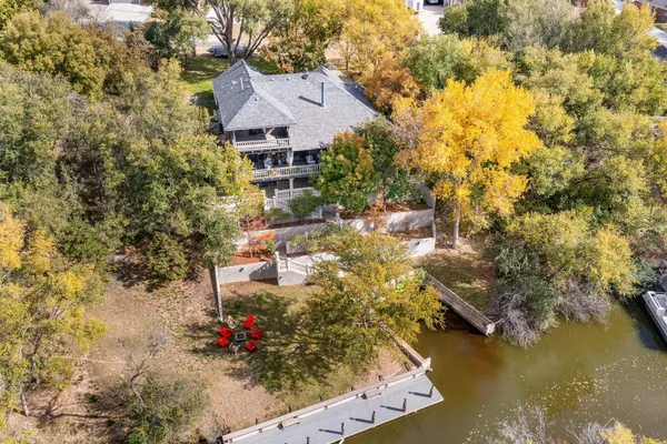 an aerial view of residential houses with outdoor space and trees