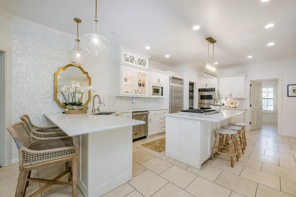 a kitchen with stainless steel appliances kitchen island granite countertop a stove a sink a dining table and chairs