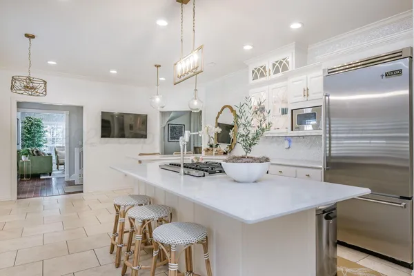 a kitchen with stainless steel appliances kitchen island granite countertop a sink a stove and cabinets