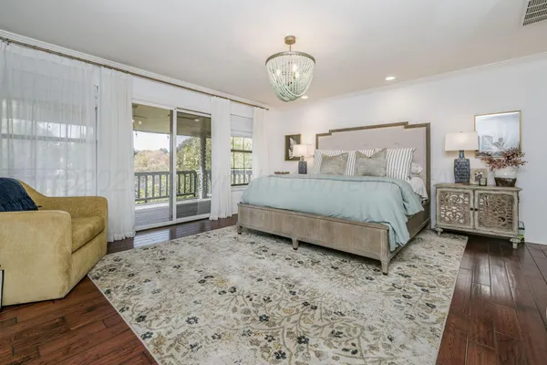 a spacious bedroom with a bed and a flat screen television