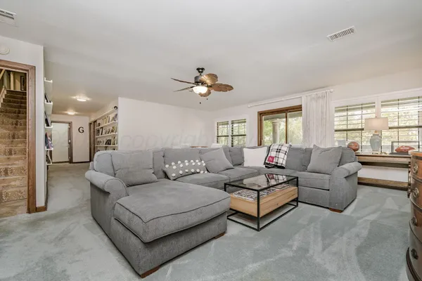 a living room with furniture a flat screen tv and kitchen view