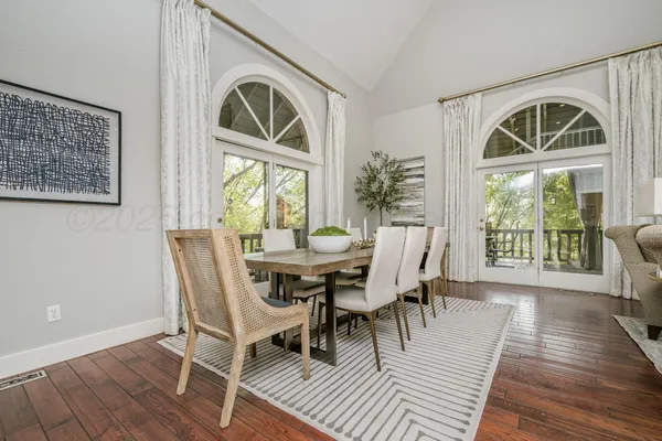 a dining room with furniture a chandelier and wooden floor